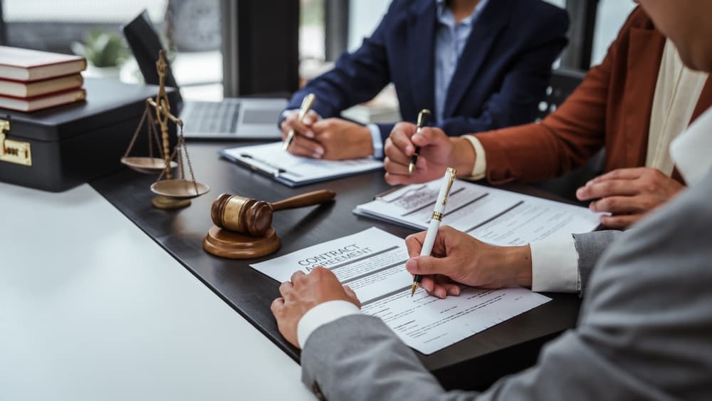 Legal consultation with lawyers team meeting for contract finalization. Lawyers discuss agreements during a contract review session.