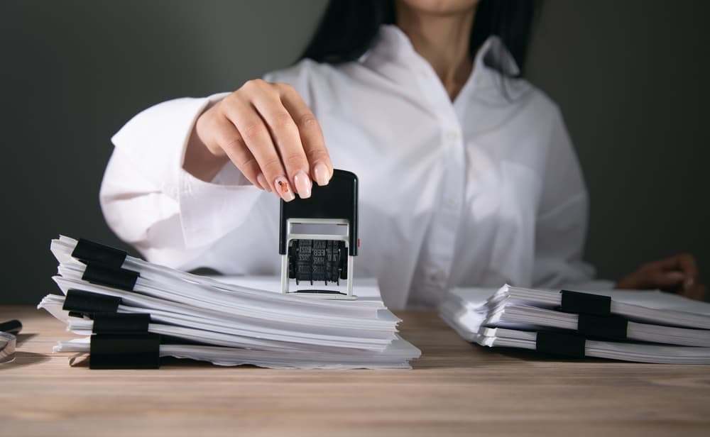 A record or permit document being stamped in an office.






