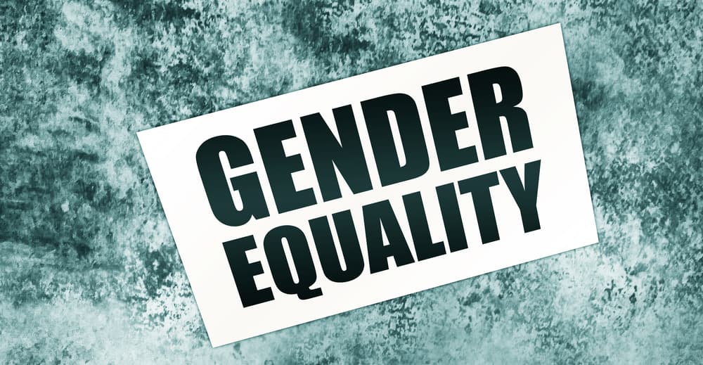 Gender Equality message on a card placed on a wooden table. Concept of equal rights and social justice.