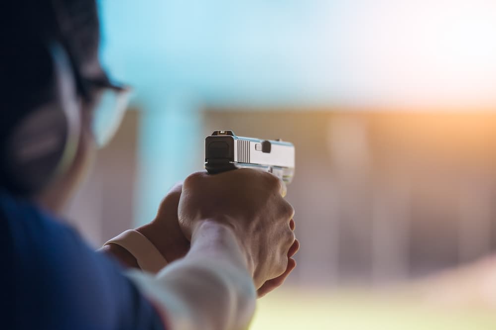 Law enforcement aim pistol by two hand in academy shooting range